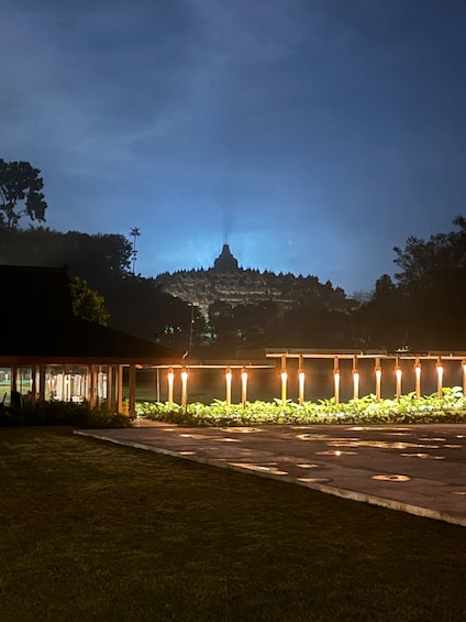 A building with a row of illuminated columns at dusk. 2