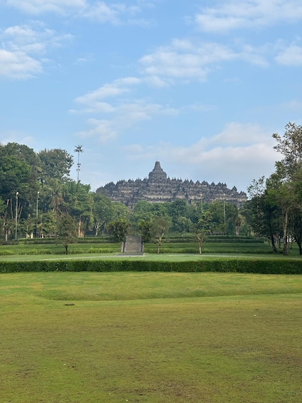 A temple complex with a central stupa, surrounded by manicured gardens and trees. 3