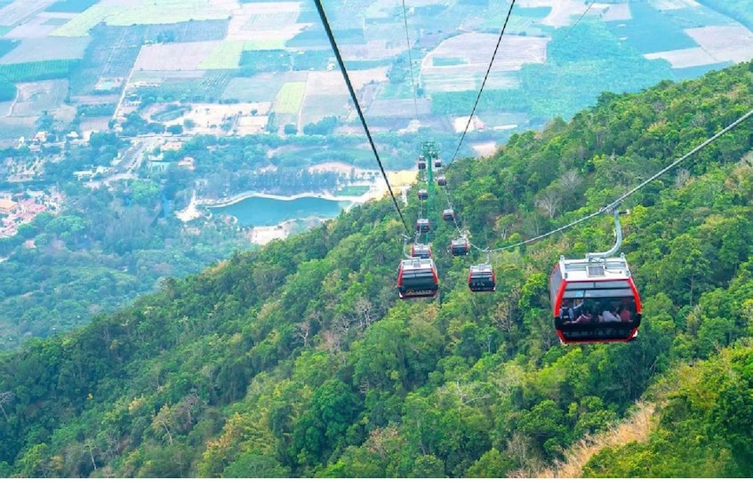 A cable car system in a mountainous area with lush greenery and a river in the background. 5