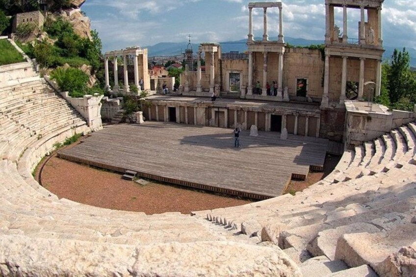Ein antikes Amphitheater mit steinernen Sitzreihen und Säulen. 5