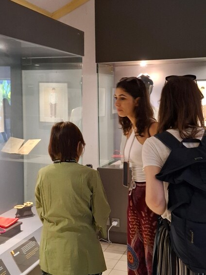 A group of people observing an exhibit in a museum. 2