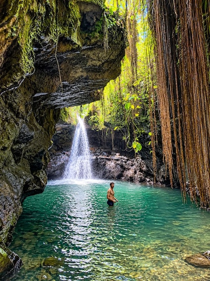 A waterfall in a natural setting with clear water and lush greenery. 1