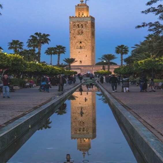 A tower with intricate architecture, a reflective waterway, and palm trees. 4
