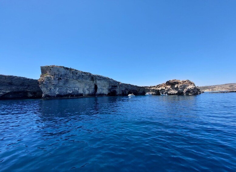 A coastal landscape with rocky cliffs and calm blue waters. 5