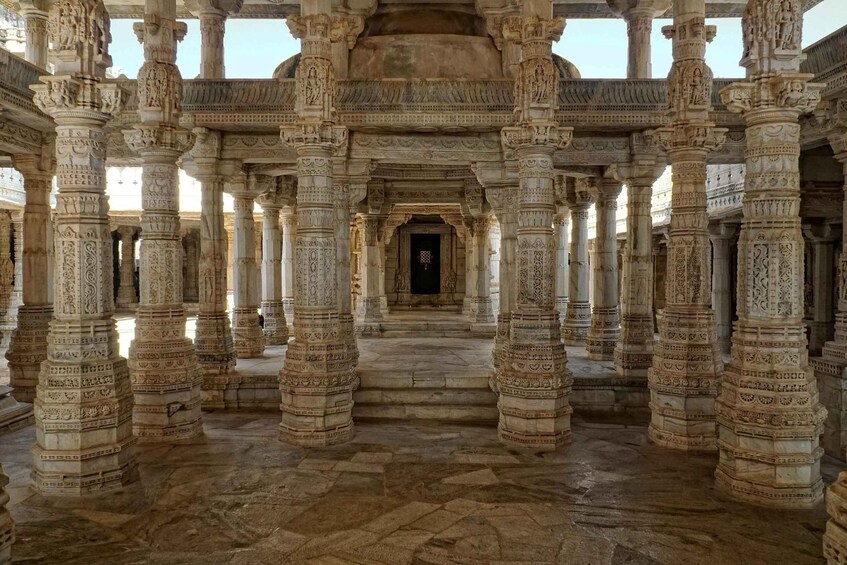 An intricately carved stone structure with multiple columns and a central doorway. 4