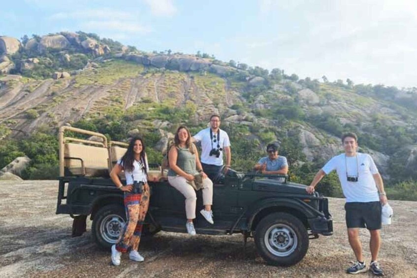 A group of people on a rocky hillside with a vehicle. 5