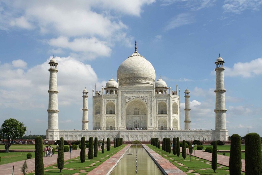 The Taj Mahal with four minarets, a central dome, and a symmetrical garden with a water channel. 3