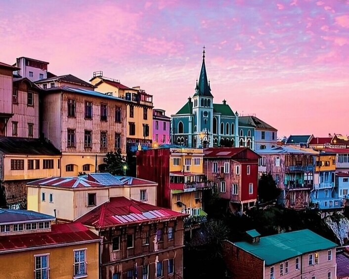 A colorful urban landscape with a prominent church spire and a variety of residential buildings. 3
