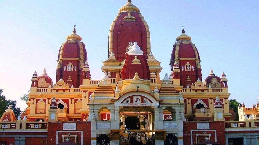 A temple with three domes, a central spire, and intricate architectural details. 5