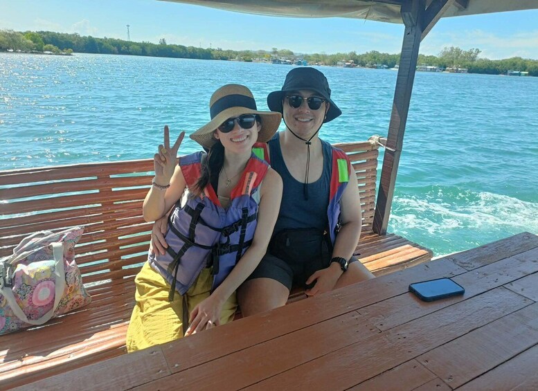 Two people on a boat with a wooden deck and a view of the water. 5