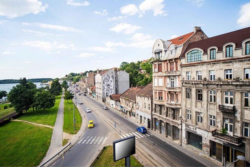 A riverside street with historic buildings, a bridge, and a river. 4
