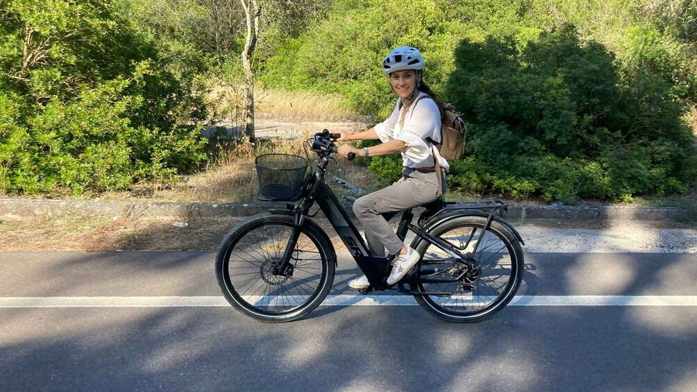 A person riding a bicycle on a road with greenery on the sides. 4