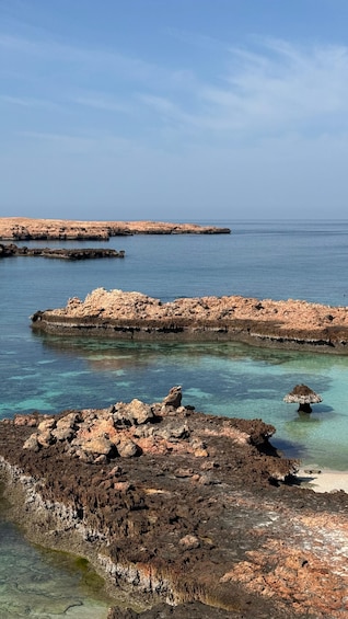 A coastal landscape with rocky formations and clear blue waters. 1