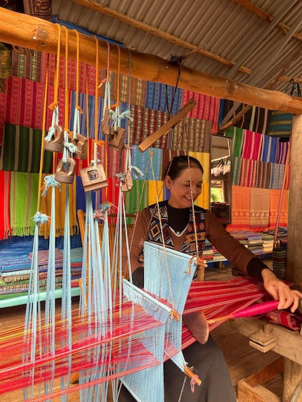 A person weaving colorful textiles on a loom. 5