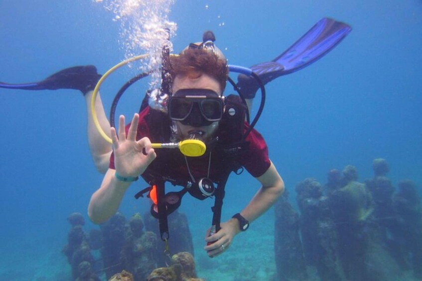 A scuba diver underwater with a snorkel and fins, surrounded by other divers. 3