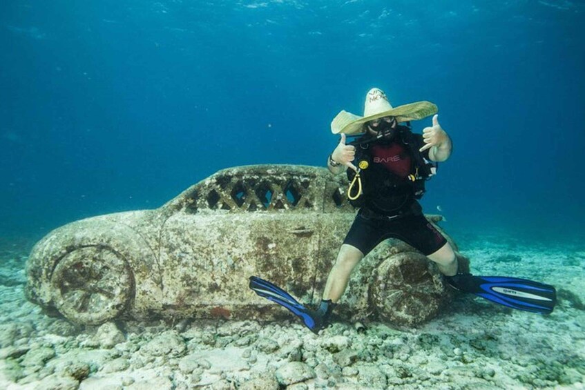 A diver near a sunken vehicle underwater. 1