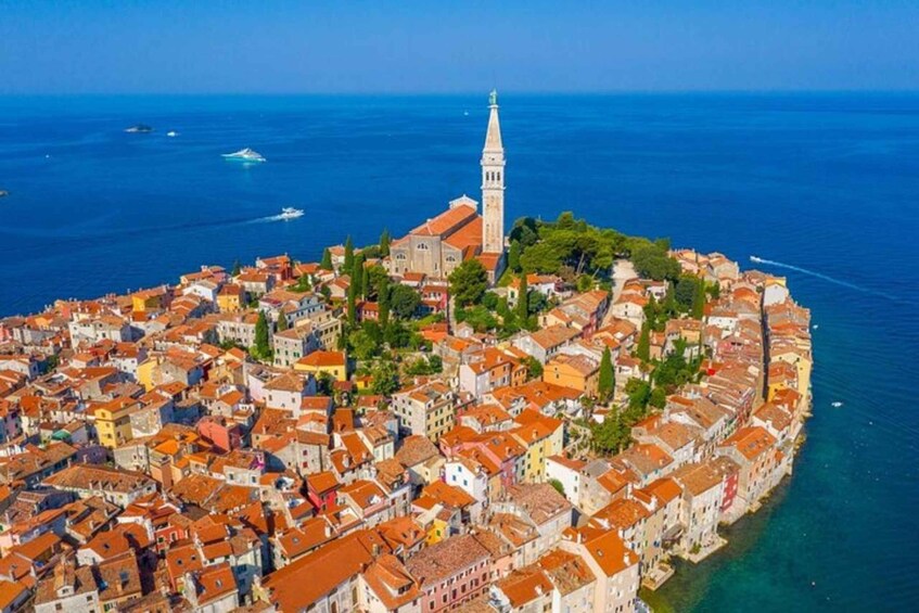An aerial view of a coastal town with a prominent church and tower, surrounded by colorful buildings and the sea. 5