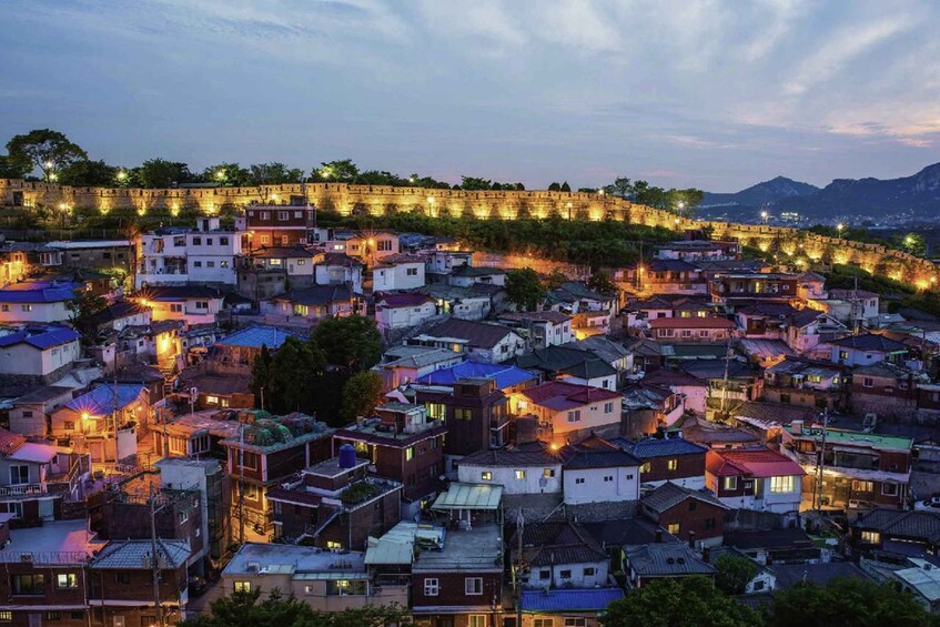 A densely packed urban area with a prominent stone wall and a mountain in the background. 3