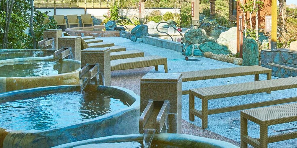 A traditional Japanese onsen with stone hot tubs and wooden benches. 5