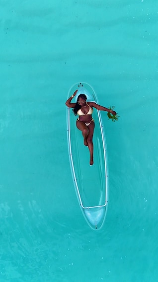 A person in a bikini lying on a clear water tube. 1