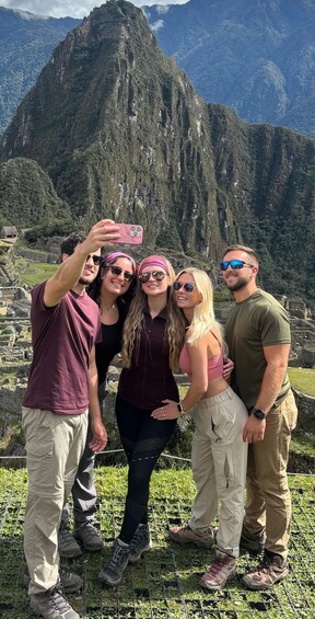 A group of people taking a selfie with Machu Picchu in the background. 4