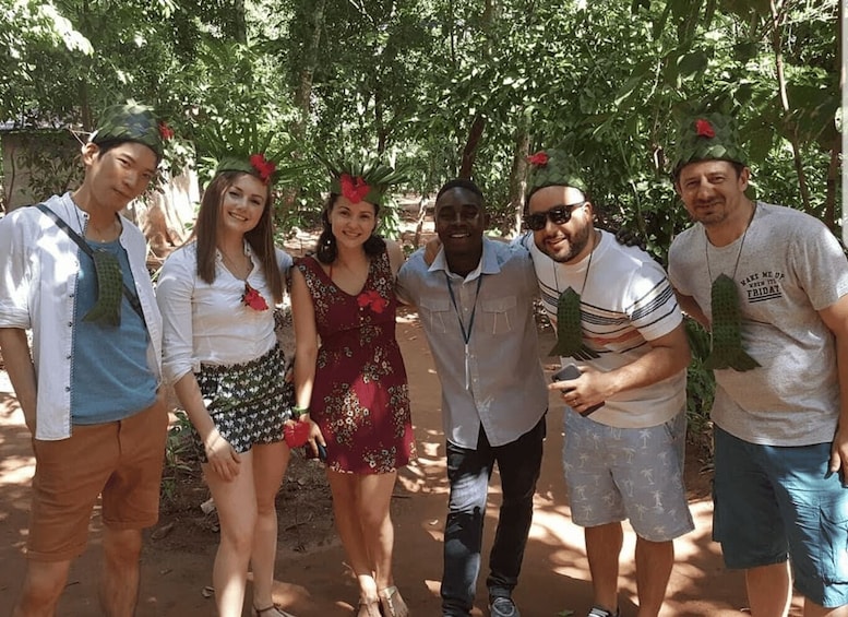A group of people outdoors, some wearing hats with leaves. 1