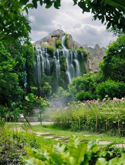 A waterfall cascading down a rocky cliff surrounded by lush greenery. 2