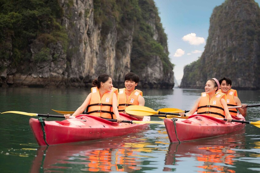 A group of people kayaking on a calm river with steep cliffs in the background. 3