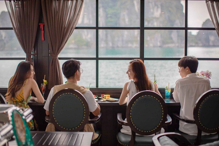 A group of people dining at a table by a window overlooking a body of water. 5