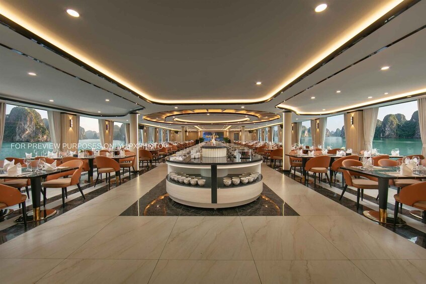 A spacious restaurant with a central island, large windows, and a view of a body of water. 5