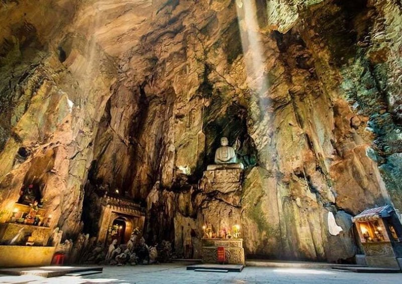 A cave temple with a large Buddha statue, intricate carvings, and a serene atmosphere. 1