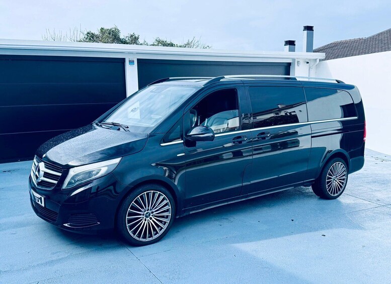 Musta Mercedes-Benz Sprinter -pakettiauto oli pysäköitynä autotallin eteen. 1
