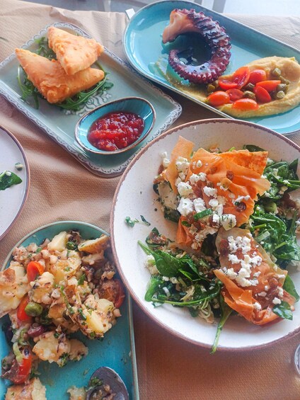 A variety of dishes including octopus, falafel, and a salad with feta cheese. 5