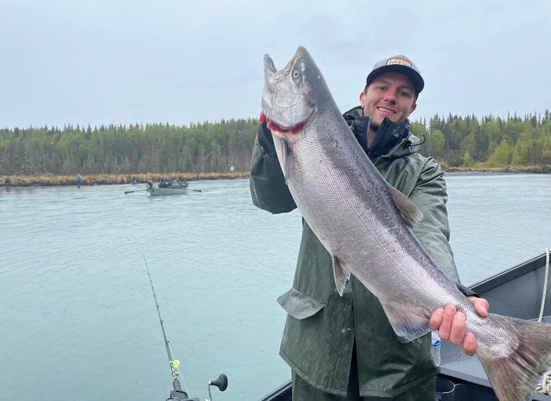 A person holding a large fish on a boat. 5