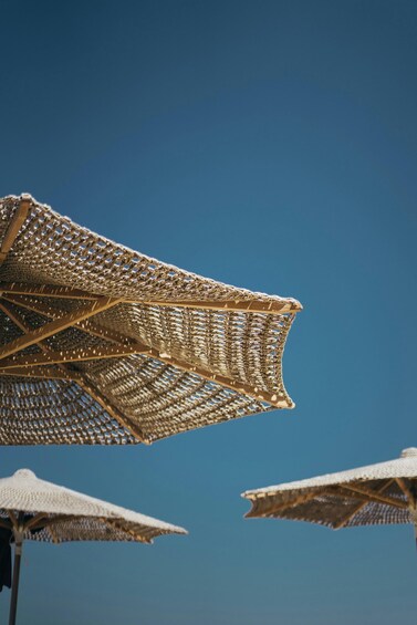 A beach with several white umbrellas. 5