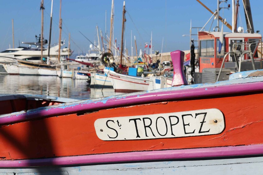 A boat with a sign reading "S. TROPEZ" in a marina with other boats. 1