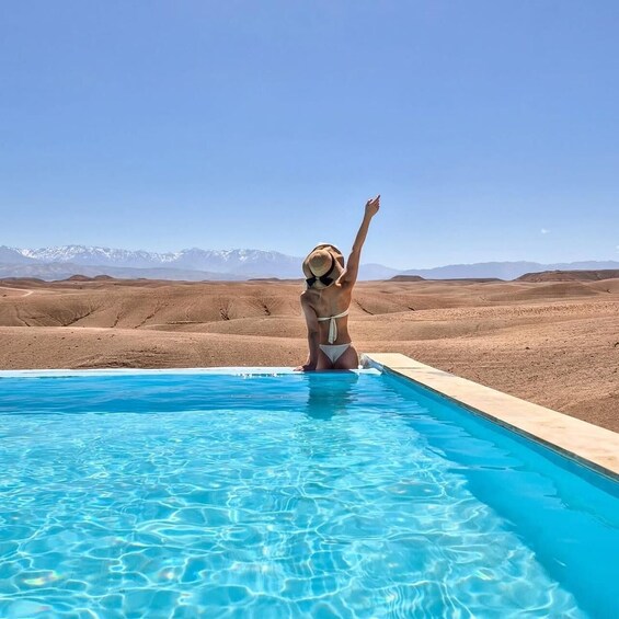 Una persona en una piscina, con un paisaje desértico y montañas al fondo. 1