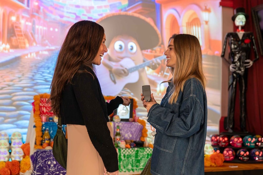 Two people in a festive setting with a large animated character and a statue in the background. 5