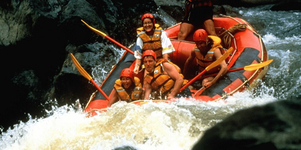 A group of people in a red raft navigating a river. 3
