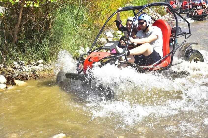 A person driving a small off-road vehicle through a shallow water body. 5