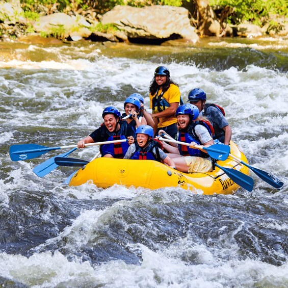 A group of people in a yellow raft navigating a river with rapids. 2