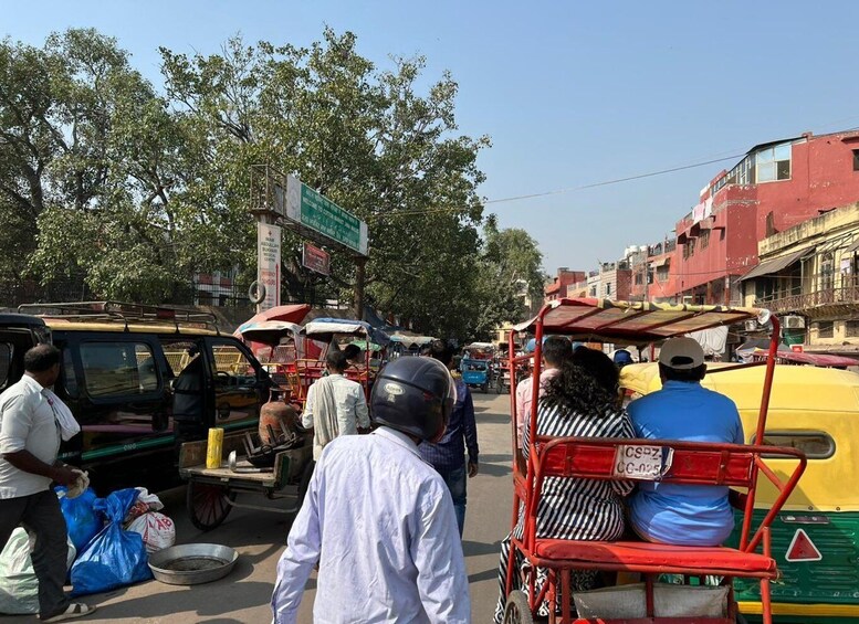 A busy street with auto-rickshaws, pedestrians, and buildings. 3