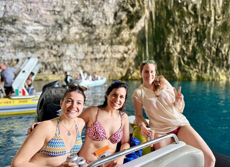 Three people in a boat on a lake with rocky cliffs in the background. 5