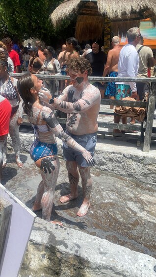 People covered in mud at an outdoor event. 1