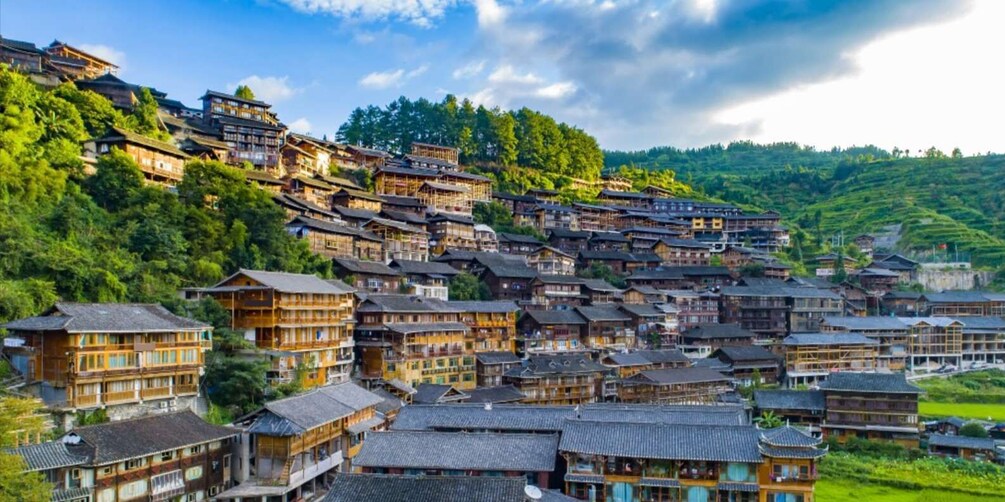 A traditional village with wooden buildings nestled in a lush, green valley. 2