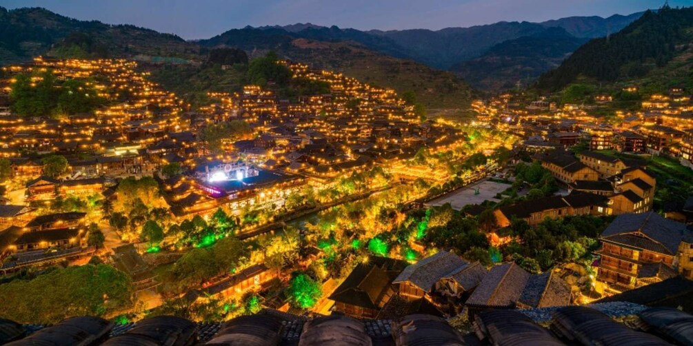 A town at night with illuminated buildings and a prominent structure in the center. 1