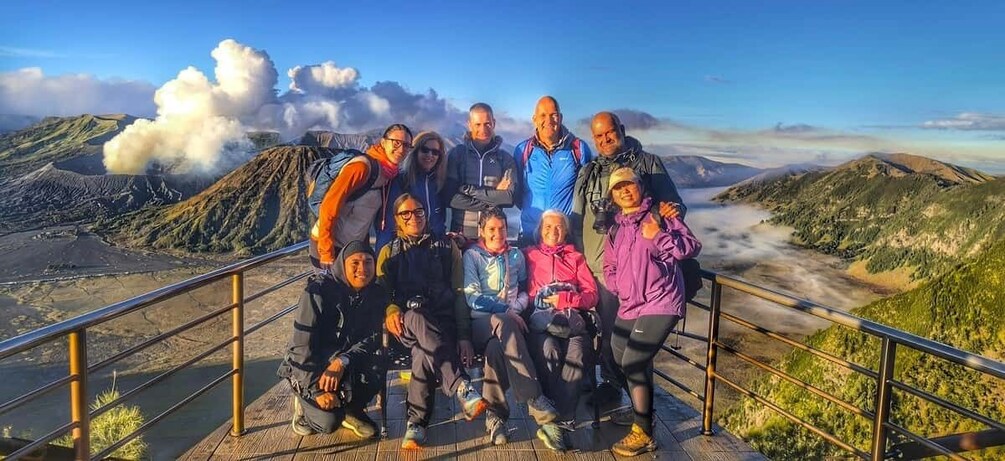 A group of people on a mountain trail with a volcano in the background. 2
