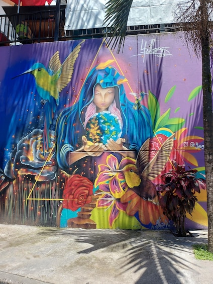 A vibrant mural with a central figure holding a globe, surrounded by colorful birds and flowers. 4