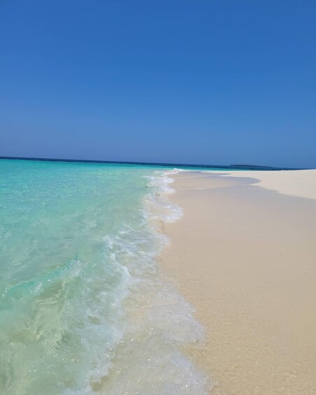 A beach with clear turquoise water and white sand. 5