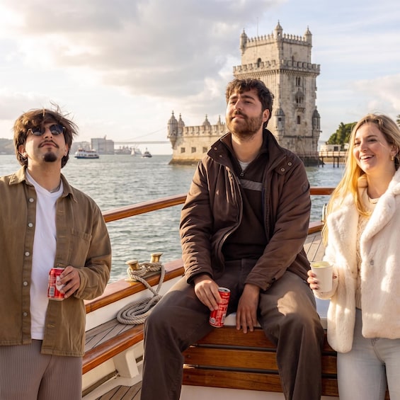 Three people on a boat with a historic tower in the background. 2